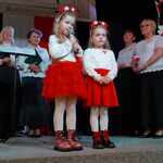 Dwie dziewczynki ubrane na biało czerwono_ stoją na scenie.  Recytują wiersz patriotyczny.  (2).jpg
