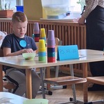 Chłopiec siedzi przy stoliku i rozwiązuje zadania logiczne..jpg